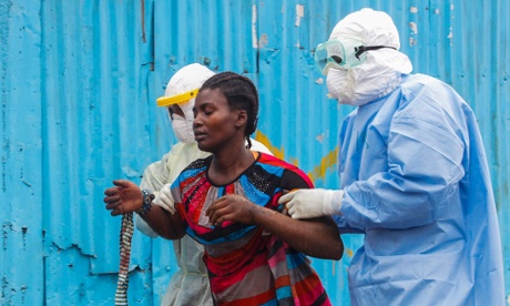 Liberian nurses escort a suspected Ebola patient into a treatment center in Monrovia