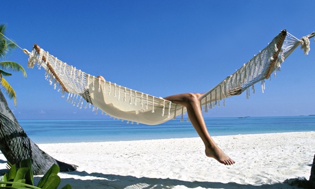 Woman lies in hammock on beach