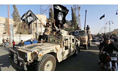 Isis fighters drive a US-made Humvee  along the streets of Syria's northern Raqqa province