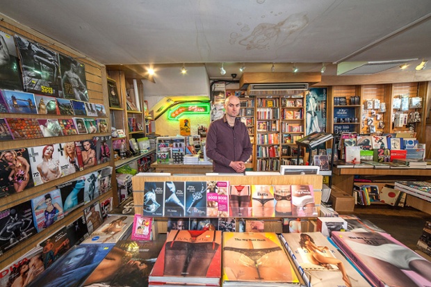 Yacek stands amongst his wares of adult books and magazines in London.