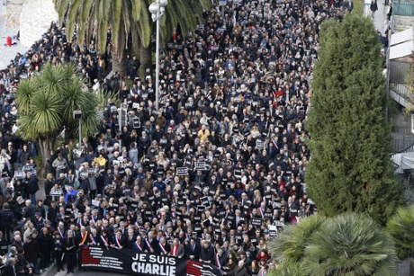 Thousands of people, some holding up signs that read, “Je suis Charlie”, march during a rally along the sea front in the Mediterranean city of Nice.
