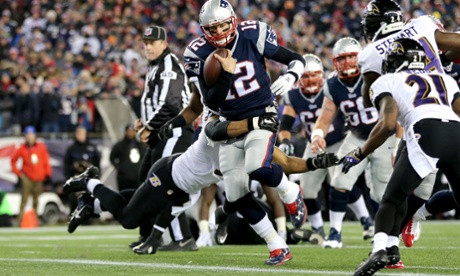 Tom Brady of the New England Patriots runs in for a touchdown in the first quarter against the Baltimore Ravens during the 2014 AFC Divisional Playoffs game at Gillette Stadium.