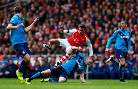Ryan Shawcross slides in on Alexis Sanchez.