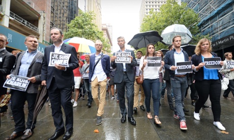 French ambassador to Australia Christophe Lecourtier (second from left) leads hundreds of marchers in Sydney's Martin Place on Sunday to pay tribute to the victims of the Paris jihadist attack.