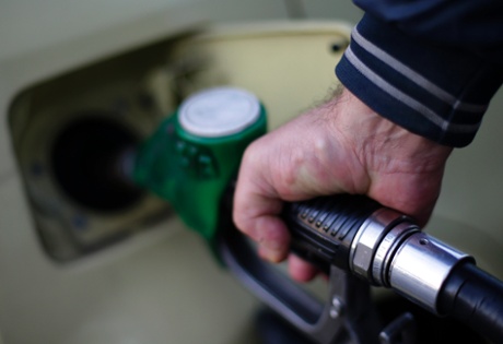 A man fills up his car at a petrol station.