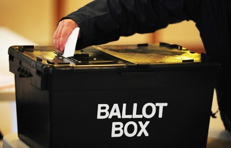 A voter places a ballot paper in the ballot box at a polling station in Derbyshire.