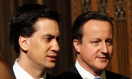 Britain's Prime Minister David Cameron and opposition Labour Party leader Ed Miliband walk together through the Members' Lobby of the House of Commons in 2012.