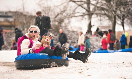 Mother and daughter sledging on a snow day