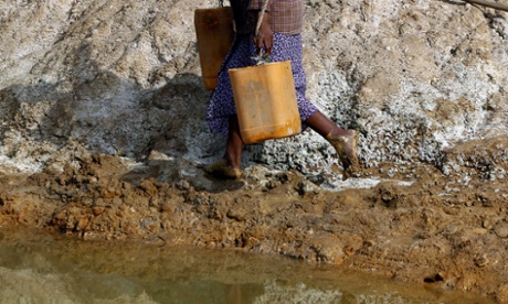 woman walks barefoot by mine water