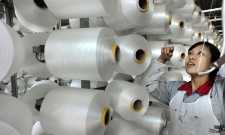 A worker checks a machine making blankets for export at a factory in Yiwu, China. 