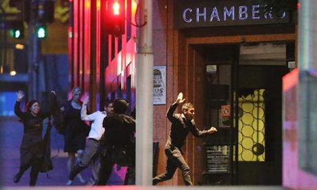 People run with their hands up from the Lindt cafe on 16 December.