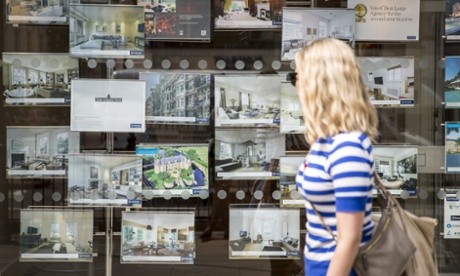 Young woman walking past an estate agents