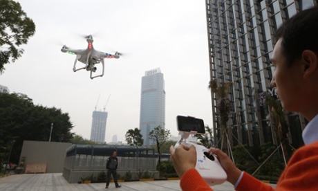A staff member from DJI Technology Co. demonstrates the remote flying with his Phantom 2 Vision+ drone in Shenzhen, south China's Guangdong province