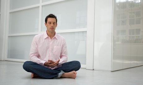 A man meditating in an office.