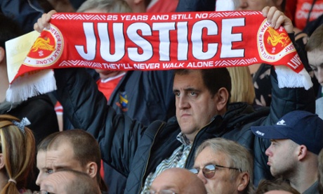 A man holds up a scarf calling for justice for the 96 killed during the minute’s silence at a memorial service to mark the 25th anniversary of the Hillsborough Disaster at Anfield on April 15, 2014. 