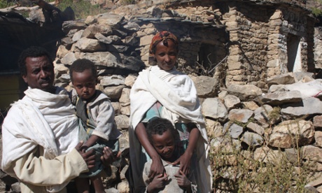 Gizat Wellu with his family in front of his three beehives.