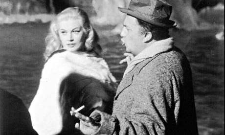 Federico Fellini, cigarette in hand, advises Anita Ekberg during the filming of La Dolce Vita