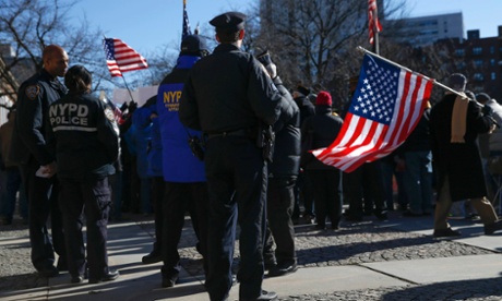 A NYPD officer stands watching a 'Support Your Local Police' rally at Queens Borough Hall in New York January 13, 2015.
