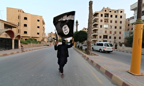 A member loyal to the Islamic State waves a flag