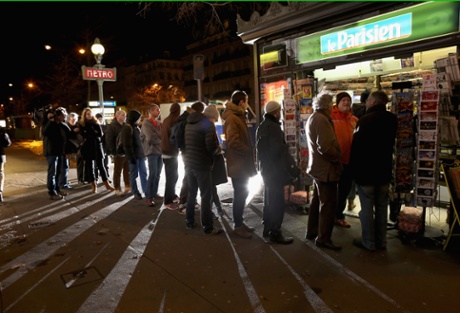 Parisians queue at a newspaper kiosk to get the the latest edition of Charlie Hebdo.
