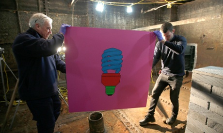 Art movers carry Michael Craig-Martin's acrylic on aluminium picture of a lightbulb, in the former Laurie Grove Baths