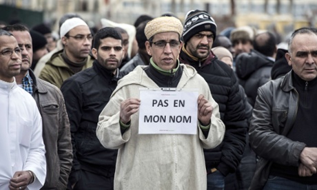 A Muslim man holds a placard reading 'Not in my name' near the mosque of Saint-Étienne, eastern France, on 9 January.