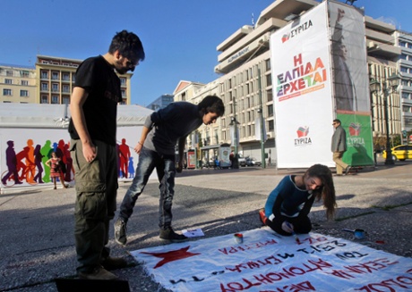 Syriza supporters paint a banner outside anelection rally in central Athens.