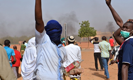 People holds rocks as they demonstrate a