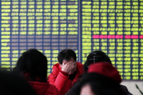 Concerned Chinese investors look at prices of shares (red for price rising and green for price falling) at a stock brokerage house in Nantong city, east China's Jiangsu province, 19 January 2015.