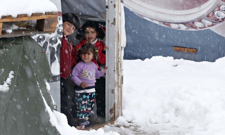 Syrian refugee children stand inside a tent at a refugee camp in Zahle, Lebanon
