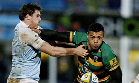 Adam Powell of Newcastle Falcons tries to halt a charge by Luther Burrell of Northampton Saints