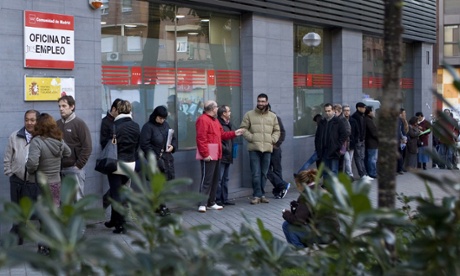 People wait in line at a government employment office on Paseo de las Acacias in Madrid on December 2, 2014.