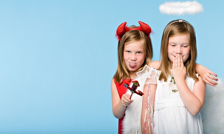 Twin girls dressed as an angel and devil