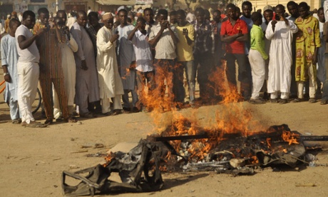 People gather at the site of a bomb explosion in a area know to be  targeted by the  militant group Boko Haram,  in Kano, Nigeria.