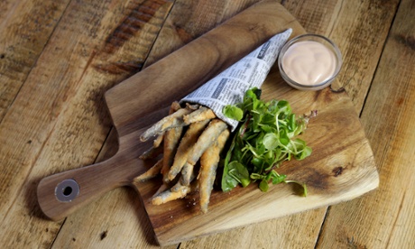Whitebait served in a cone of newspaper with a small dish of pink Marie Rose sauce by the side
