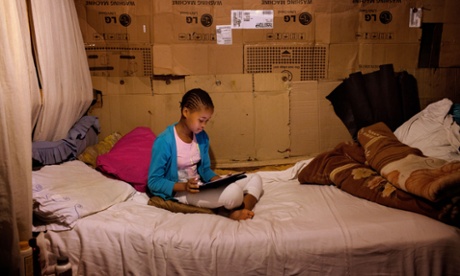 Phelela, 13 years old, doing homework on an iPad in her bedroom in Nyanga, Cape Town, South Africa.