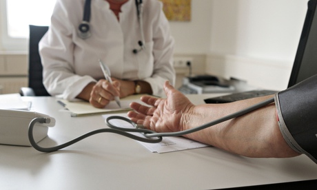 Doctor takes patients blood pressure-detail