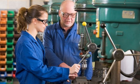 Female apprentice being taught to drill