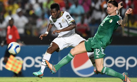 Ghanaian forward Asamoah Gyan scores the decisive goal past Algeria's defender Carl Medjani.