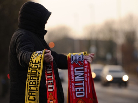 A vendor outside the Abbey Stadium with a half and half scarf for Cambridge United's FA Cup fourth-round tie against Manchester United.