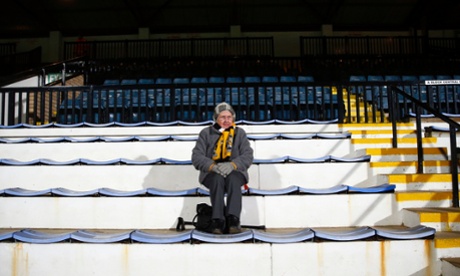 A Cambridge United fan sits alone on her seat before their FA Cup fourth-round match against Manchester United at The Abbey Stadium.