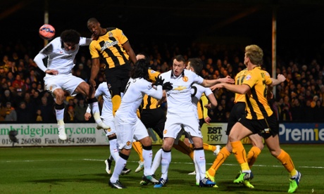Cambridge United's Tom Elliott heads towards goal under pressure from Marouane Fellaini. Elliott and his team have made a positive start.