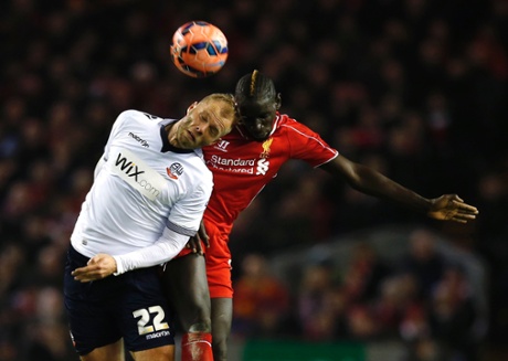 Liverpool's Mamadou Sakho, right, and Bolton Wanderers' Eidur Gudjohnsen go up for a header.