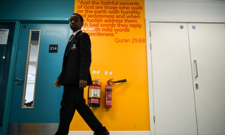 A pupil walks past an excerpt from the Qur'an, which are on walls throughout the school.