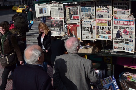 People read headlines of newspapers on January 26, 2015  in Athens.