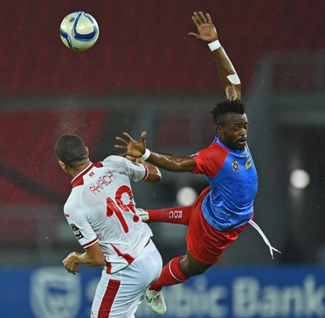 Democratic Republic of the Congo's Issama Mpeko jumps dramatically as he tries to head the ball away from Tunisian forward Ahmed Akaichi.