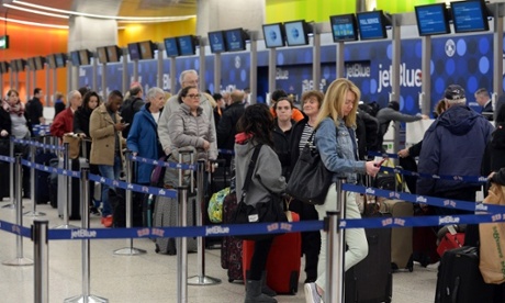 Travelers stand in line in Terminal C at Logan International Airport.