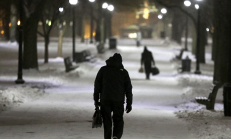 Pedestrians walk along a snow-covered path in the Boston Common