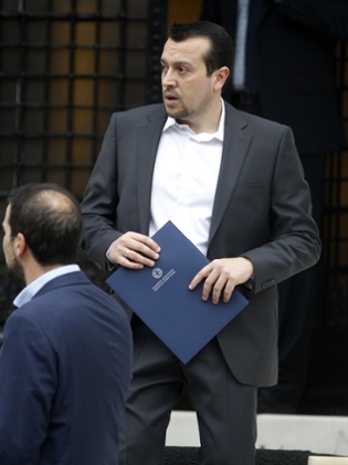 New State Minister Nikos Pappas holds a folder as he leaves the Prime Minister's office to name the new cabinet in Athens on Tuesday, Jan. 27, 2015.