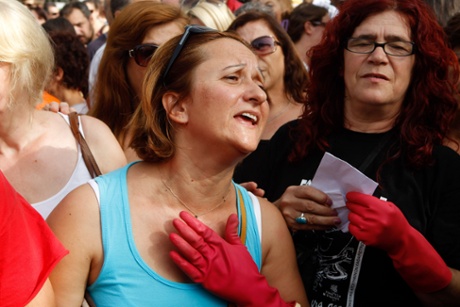 Laid-off finance ministry cleaning staff, wearing cleaning gloves, shout slogans outside the Supreme Court during a protest in Athens.